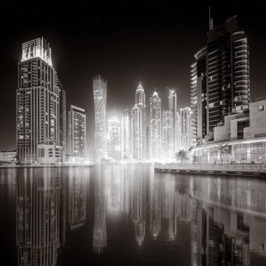 Aydınlatılmış gökdelenleri ve gece siyah beyaz rıhtımlı şehir silüeti, kentsel gelişim konsepti, Dubai Marina Körfezi BAE