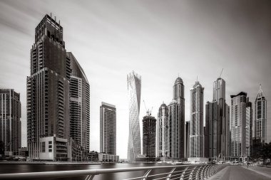 Gökdelenler ve su üzerindeki köprü, siyah-beyaz tarzı, şehir arkaplanı, şehir gelişimi konsepti, Dubai Marina körfezi BAE