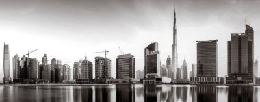 Tek renkli şehir gökdelenleri bulutlu bir gökyüzü altında sakin suyu yansıtan gökdelenler, kentsel gelişim konsepti, Dubai Marina Körfezi BAE