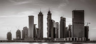 Tek renkli şehir gökdelenleri bulutlu bir gökyüzü altında sakin suyu yansıtan gökdelenler, kentsel gelişim konsepti, Dubai Marina Körfezi BAE