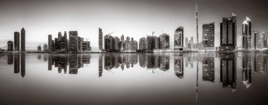 Tek renkli şehir gökdelenleri bulutlu bir gökyüzü altında sakin suyu yansıtan gökdelenler, kentsel gelişim konsepti, Dubai Marina Körfezi BAE