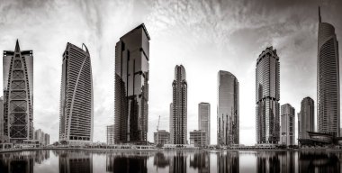 Gökdelenler ve su üzerindeki köprü, siyah-beyaz tarzı, şehir arkaplanı, şehir gelişimi konsepti, Dubai Marina körfezi BAE