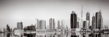 Tek renkli şehir gökdelenleri bulutlu bir gökyüzü altında sakin suyu yansıtan gökdelenler, kentsel gelişim konsepti, Dubai Marina Körfezi BAE