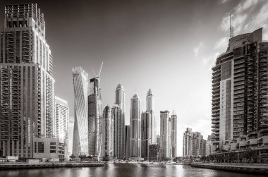 Gökdelenler ve su üzerindeki köprü, siyah-beyaz tarzı, şehir arkaplanı, şehir gelişimi konsepti, Dubai Marina körfezi BAE