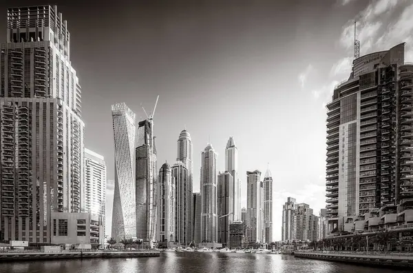 Gökdelenler ve su üzerindeki köprü, siyah-beyaz tarzı, şehir arkaplanı, şehir gelişimi konsepti, Dubai Marina körfezi BAE
