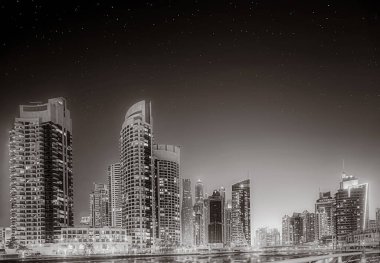 Tek renkli şehir gökdelenleri bulutlu bir gökyüzü altında sakin suyu yansıtan gökdelenler, kentsel gelişim konsepti, Dubai Marina Körfezi BAE