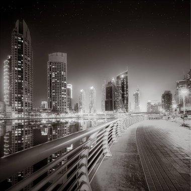 Gökdelenler ve su üzerindeki köprü, siyah-beyaz tarzı, şehir arkaplanı, şehir gelişimi konsepti, Dubai Marina körfezi BAE