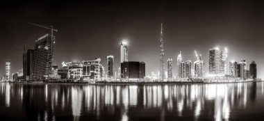 Aydınlatılmış gökdelenleri ve gece siyah beyaz rıhtımlı şehir silüeti, kentsel gelişim konsepti, Dubai Marina Körfezi BAE