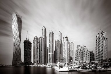 Gökdelenler ve su üzerindeki köprü, siyah-beyaz tarzı, şehir arkaplanı, şehir gelişimi konsepti, Dubai Marina körfezi BAE