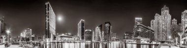Gökdelenler ve su üzerindeki köprü, siyah-beyaz tarzı, şehir arkaplanı, şehir gelişimi konsepti, Dubai Marina körfezi BAE