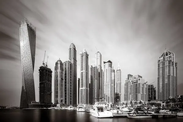 Gökdelenler ve su üzerindeki köprü, siyah-beyaz tarzı, şehir arkaplanı, şehir gelişimi konsepti, Dubai Marina körfezi BAE