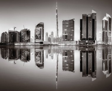 Aydınlatılmış gökdelenleri ve gece siyah beyaz rıhtımlı şehir silüeti, kentsel gelişim konsepti, Dubai Marina Körfezi BAE