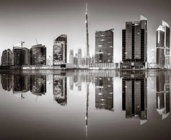 Aydınlatılmış gökdelenleri ve gece siyah beyaz rıhtımlı şehir silüeti, kentsel gelişim konsepti, Dubai Marina Körfezi BAE