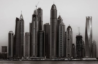 Gökdelenler ve su üzerindeki köprü, siyah-beyaz tarzı, şehir arkaplanı, şehir gelişimi konsepti, Dubai Marina körfezi BAE