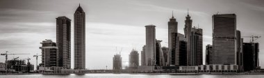 Aydınlatılmış gökdelenleri ve gece siyah beyaz rıhtımlı şehir silüeti, kentsel gelişim konsepti, Dubai Marina Körfezi BAE