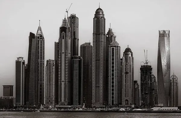 Gökdelenler ve su üzerindeki köprü, siyah-beyaz tarzı, şehir arkaplanı, şehir gelişimi konsepti, Dubai Marina körfezi BAE