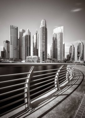 Gökdelenler ve su üzerindeki köprü, siyah-beyaz tarzı, şehir arkaplanı, şehir gelişimi konsepti, Dubai Marina körfezi BAE