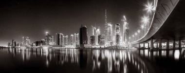 Gökdelenler ve su üzerindeki köprü, siyah-beyaz tarzı, şehir arkaplanı, şehir gelişimi konsepti, Dubai Marina körfezi BAE