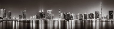 Tek renkli şehir gökdelenleri bulutlu bir gökyüzü altında sakin suyu yansıtan gökdelenler, kentsel gelişim konsepti, Dubai Marina Körfezi BAE