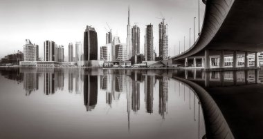 Gökdelenler ve su üzerindeki köprü, siyah-beyaz tarzı, şehir arkaplanı, şehir gelişimi konsepti, Dubai Marina körfezi BAE