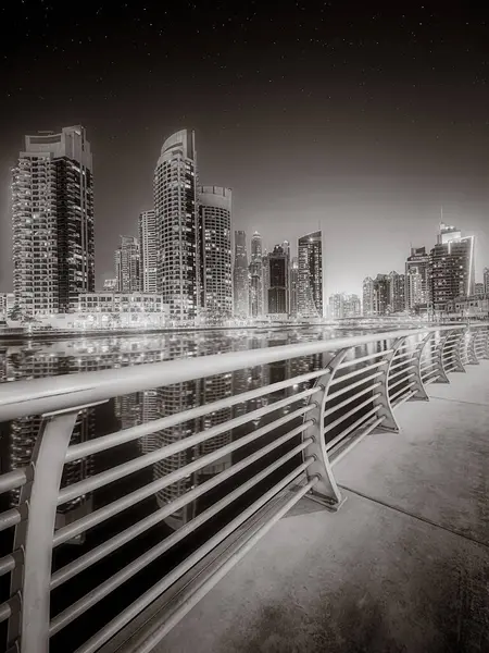Gökdelenler ve su üzerindeki köprü, siyah-beyaz tarzı, şehir arkaplanı, şehir gelişimi konsepti, Dubai Marina körfezi BAE