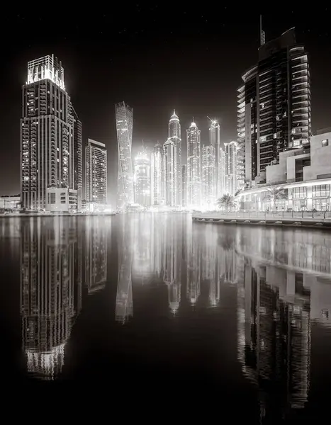 Aydınlatılmış gökdelenleri ve gece siyah beyaz rıhtımlı şehir silüeti, kentsel gelişim konsepti, Dubai Marina Körfezi BAE