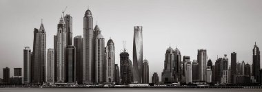 Tek renkli şehir gökdelenleri bulutlu bir gökyüzü altında sakin suyu yansıtan gökdelenler, kentsel gelişim konsepti, Dubai Marina Körfezi BAE