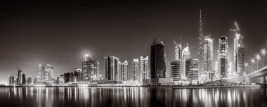 Gökdelenler ve su üzerindeki köprü, siyah-beyaz tarzı, şehir arkaplanı, şehir gelişimi konsepti, Dubai Marina körfezi BAE
