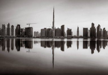 Tek renkli şehir gökdelenleri bulutlu bir gökyüzü altında sakin suyu yansıtan gökdelenler, kentsel gelişim konsepti, Dubai Marina Körfezi BAE