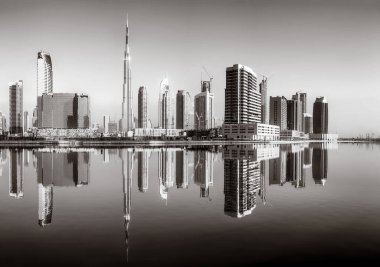 Tek renkli şehir gökdelenleri bulutlu bir gökyüzü altında sakin suyu yansıtan gökdelenler, kentsel gelişim konsepti, Dubai Marina Körfezi BAE