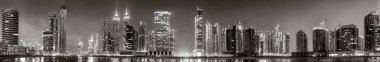 Tek renkli şehir gökdelenleri bulutlu bir gökyüzü altında sakin suyu yansıtan gökdelenler, kentsel gelişim konsepti, Dubai Marina Körfezi BAE