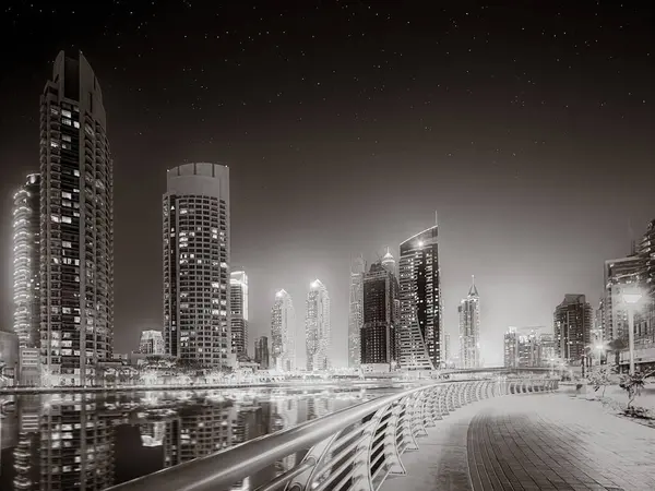 Gökdelenler ve su üzerindeki köprü, siyah-beyaz tarzı, şehir arkaplanı, şehir gelişimi konsepti, Dubai Marina körfezi BAE