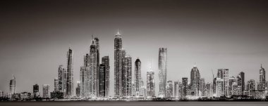 Aydınlatılmış gökdelenleri ve gece siyah beyaz rıhtımlı şehir silüeti, kentsel gelişim konsepti, Dubai Marina Körfezi BAE