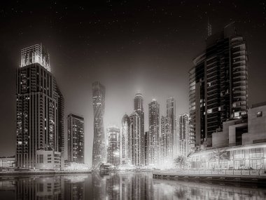 Gökdelenler ve su üzerindeki köprü, siyah-beyaz tarzı, şehir arkaplanı, şehir gelişimi konsepti, Dubai Marina körfezi BAE