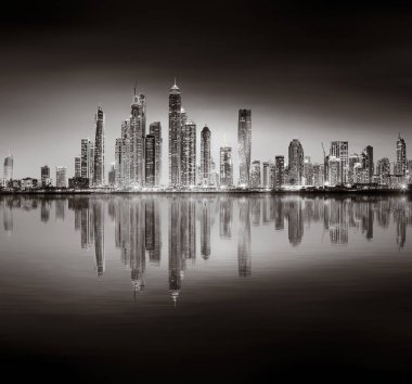 Aydınlatılmış gökdelenleri ve gece siyah beyaz rıhtımlı şehir silüeti, kentsel gelişim konsepti, Dubai Marina Körfezi BAE