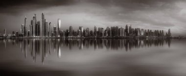 Tek renkli şehir gökdelenleri bulutlu bir gökyüzü altında sakin suyu yansıtan gökdelenler, kentsel gelişim konsepti, Dubai Marina Körfezi BAE