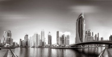 Gökdelenler ve su üzerindeki köprü, siyah-beyaz tarzı, şehir arkaplanı, şehir gelişimi konsepti, Dubai Marina körfezi BAE