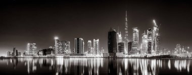 Aydınlatılmış gökdelenleri ve gece siyah beyaz rıhtımlı şehir silüeti, kentsel gelişim konsepti, Dubai Marina Körfezi BAE