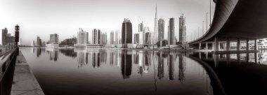 Gökdelenler ve su üzerindeki köprü, siyah-beyaz tarzı, şehir arkaplanı, şehir gelişimi konsepti, Dubai Marina körfezi BAE