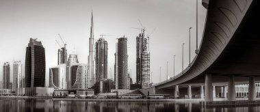 Gökdelenler ve su üzerindeki köprü, siyah-beyaz tarzı, şehir arkaplanı, şehir gelişimi konsepti, Dubai Marina körfezi BAE