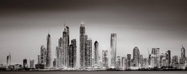 Aydınlatılmış gökdelenleri ve gece siyah beyaz rıhtımlı şehir silüeti, kentsel gelişim konsepti, Dubai Marina Körfezi BAE