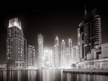 Gökdelenler ve su üzerindeki köprü, siyah-beyaz tarzı, şehir arkaplanı, şehir gelişimi konsepti, Dubai Marina körfezi BAE