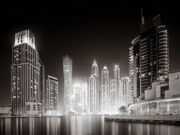Gökdelenler ve su üzerindeki köprü, siyah-beyaz tarzı, şehir arkaplanı, şehir gelişimi konsepti, Dubai Marina körfezi BAE