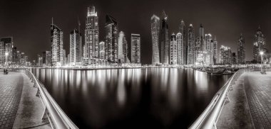 Aydınlatılmış gökdelenleri ve gece siyah beyaz rıhtımlı şehir silüeti, kentsel gelişim konsepti, Dubai Marina Körfezi BAE