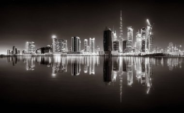 Aydınlatılmış gökdelenleri ve gece siyah beyaz rıhtımlı şehir silüeti, kentsel gelişim konsepti, Dubai Marina Körfezi BAE