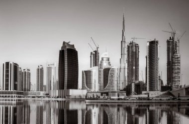 Tek renkli şehir gökdelenleri bulutlu bir gökyüzü altında sakin suyu yansıtan gökdelenler, kentsel gelişim konsepti, Dubai Marina Körfezi BAE