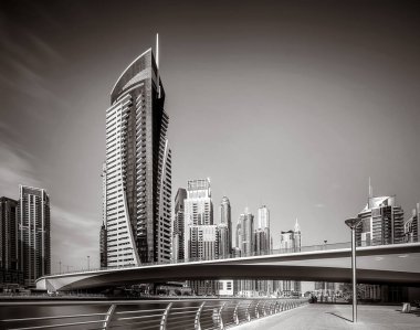 Gökdelenler ve su üzerindeki köprü, siyah-beyaz tarzı, şehir arkaplanı, şehir gelişimi konsepti, Dubai Marina körfezi BAE