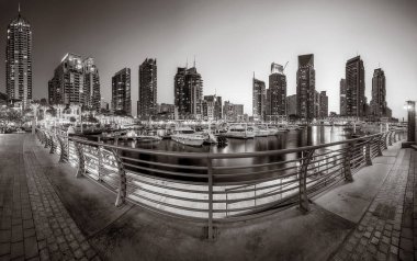 Gökdelenler ve su üzerindeki köprü, siyah-beyaz tarzı, şehir arkaplanı, şehir gelişimi konsepti, Dubai Marina körfezi BAE