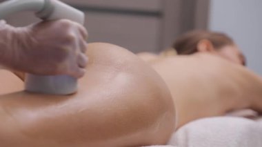 Güzel bir vücudu olan genç bir kadına kalçalarına masaj yapılır..