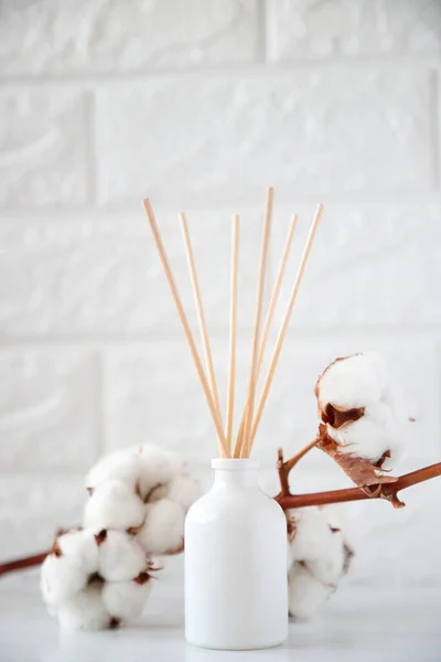 The aroma reed diffuser with the stick perfume are decorated in the room minimal design idea with cotton flowers